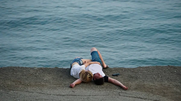 Glückliches Paar im Sommerurlaub. Menschen, die am Abend am Strand liegen. — Stockfoto