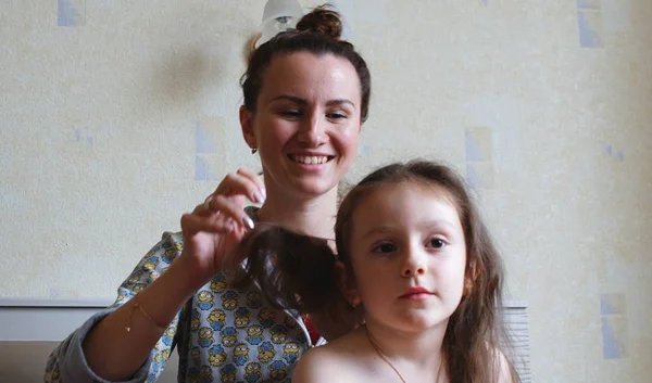 Matka styl a włosy dla jej nastoletnie córka w pokój wnętrze. — Zdjęcie stockowe