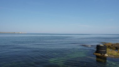 Sahilde eski lastikleri ile güzel deniz ve mavi gökyüzü