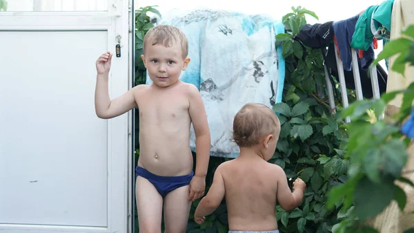 Bahçede iki küçük çocuk var. Büyük çocuk önünde ve arka daha küçük kalan — Stok fotoğraf