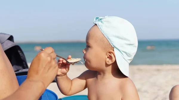 Dziecko na plaży morskiej nie chcą jeść owsiankę i usuwa łyżkę z twarzy — Zdjęcie stockowe