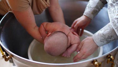 Vaftiz ayini. Bebeği vaftiz etmek. Çocuk, rahip ve vaftiz babası.