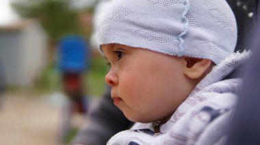 Oyun alanında açık beyaz şapkalı sevimli bebek