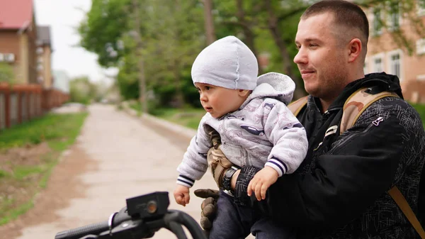 Hommes adultes souriants tenant mignon petit bébé sur ses bras — Photo