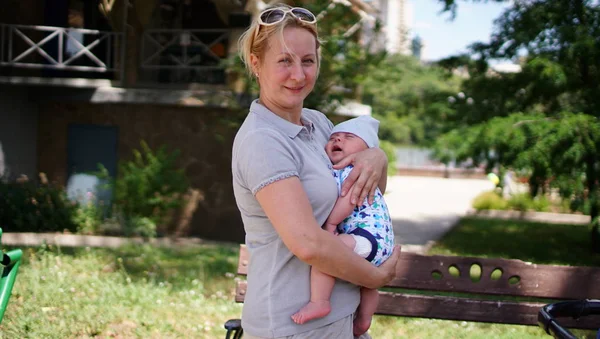 Yeni doğan çocuğunu tutan bir anne. Kadın ve yeni doğan çocuk parkta dinlenmek.