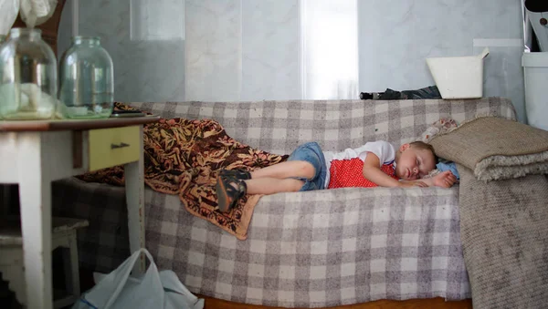 Menino dormindo em um sofá em uma casa de campo — Fotografia de Stock