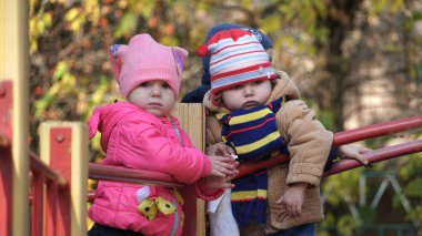 Çocuklar parkta oyun parkında oynarlar. Mutlu çocuk sonbaharda dışarıda.