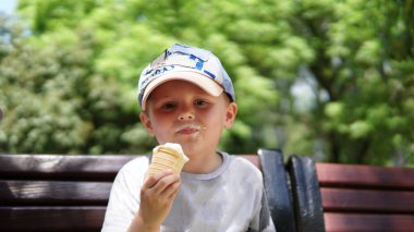 Küçük bir çocuğun portresi. Parkta dondurmalı bir çocuk.
