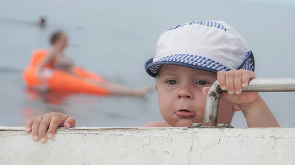 Cute Dziecko Uważnym Spojrzeniem Trzymając Uchwyt Łodzi Morzu — Zdjęcie stockowe