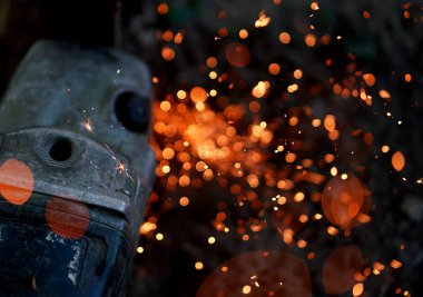 Disk öğütücüsüyle metal kesmek. Bulanık kıvılcımlar ve eski ekipmanlar