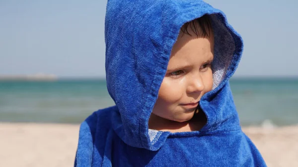 Szczelny Portret Zadowolonego Dziecka Niebieskim Kapturze Szlafroka Stojącego Plaży Morskiej — Zdjęcie stockowe