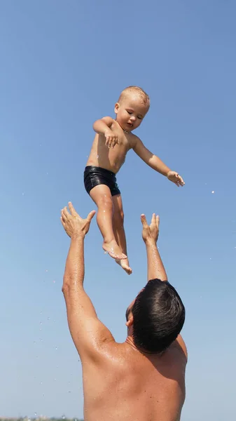Genç Baba Denizde Duruyor Korkmuş Küçük Çocuğu Yükseğe Fırlatıyor — Stok fotoğraf