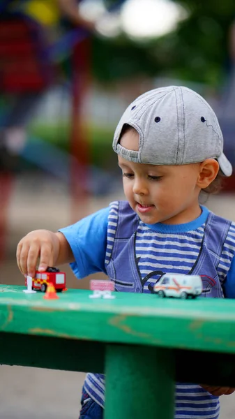 Kleiner Süßer Junge Mit Hut Spielt Auf Spielplatz Mit Spielzeugautos — Stockfoto