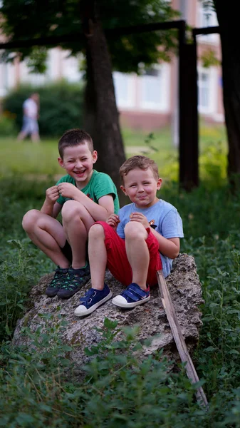 Dos Chicos Graciosos Sentados Una Gran Piedra Parque Niños Sonriendo — Foto de Stock