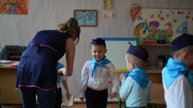 Beyaz gömlekli ve mavi kravatlı şirin bir robot tatilde bir çocuk partisine hazırlanıyor.