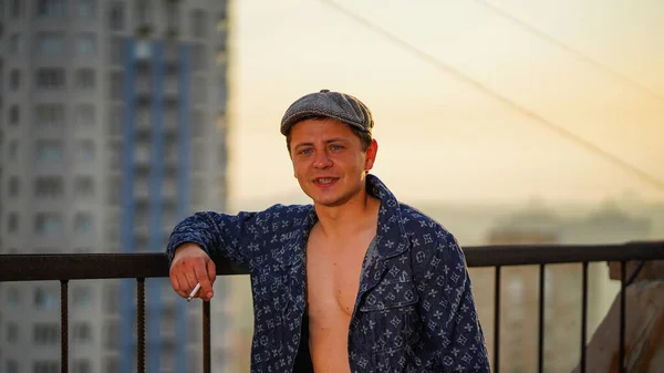 Smart Guy Unbuttoned Shirt Flat Cap Holding Sigarette Roof Building — Stock Photo, Image