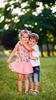 Şirin küçük kız ve oğlan dışarıda birbirlerine sarılıyorlar. İlk çocukluk ilişkisi