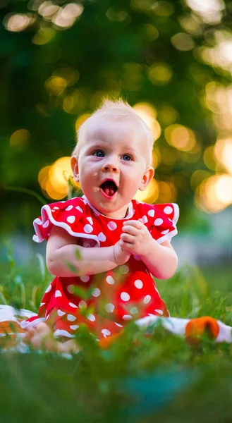 Małe Dziecko Różowej Sukience Kropki Siedzi Zielonych Trawach Letnim Parku — Zdjęcie stockowe