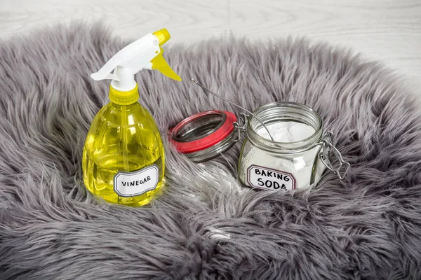Spray white vinegar dilution with water and baking soda (Sodium bicarbonate) in glass jar. Long hair fur carpet cleaning and stain removal, removing smell concept. Natural home cleaners.