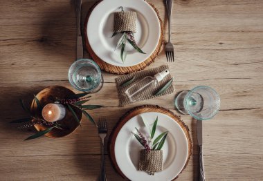 Restoran masasının ortasında el dezenfektanı şişesi var. Yaprak ve çiçek desenli beyaz tabaklar. Virüs önleme yayıyor, yeni gerçeklik. 