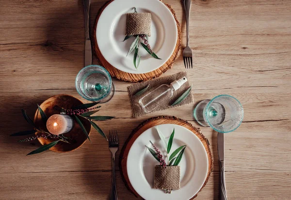 Restoran masasının ortasında el dezenfektanı şişesi var. Yaprak ve çiçek desenli beyaz tabaklar. Virüs önleme yayıyor, yeni gerçeklik. 