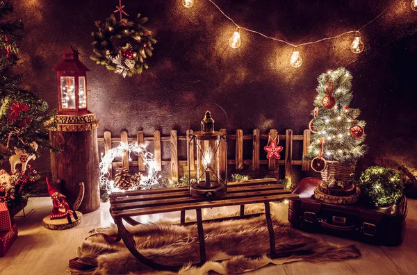 圣诞主题安排在漆黑的晚上的家房间里 许多派对的彩灯亮着 灯笼亮着 古老的复古风情 小小的圣诞树和干橙片 旧行李箱 羊皮地毯 — 图库照片
