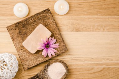 Portakallı kuru Himalaya kristal sabunu ahşap zemin üzerinde ahşap kaşık ve pembe Himalaya kristal tuz taneleri. Çiçek çiçeği süslemesi. Alternatif tıp konsepti.