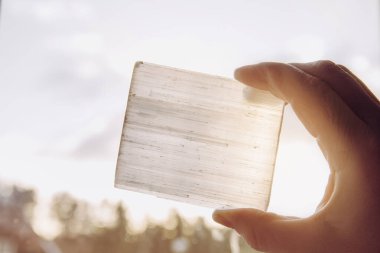  Güneş ve mavi gökyüzüne karşı doğal mineral taşı taşıyan kişi taşın iyileştirici ve arındırıcı özellikleri vardır. Ayrıca diğer mineral kristal taşlarını şarj etmek için kullanılır..