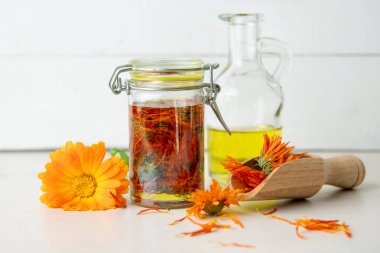 Ev yapımı Calendula officinalis yapmak normal kadife çiçeği yağı cam kavanozda. Kuru çiçekler, yararlı bileşiklerini ayıklamak için birkaç hafta boyunca oda sıcaklığında zeytinyağına bulanırlar..