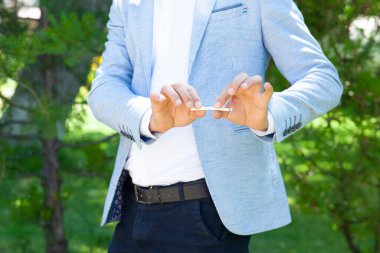 Erkek eli sigarayı sokakta kırar.