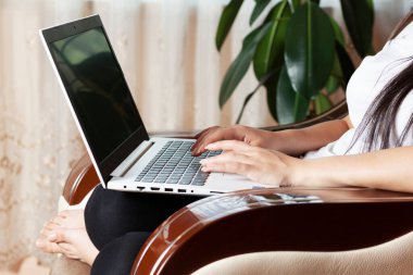 Kadın bilgisayar koltuğunda çalışıyor.