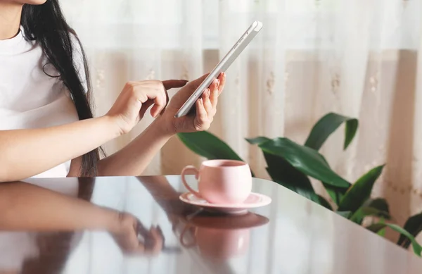 woman hand tablet with coffee on the desk