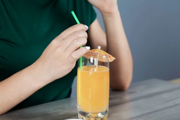 woman hand Orange juice on the desk