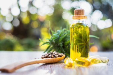 CBD kenevir yağı, tahta kaşıkta kenevir tohumu ve masaya konan CBD yağının tabletleri, doğal arka plan Alternatif tıp kavramları..