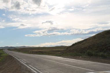bozkır beyaz bulutlar Sayan Dağları Sibirya Rusya ile mavi gökyüzü altında yol