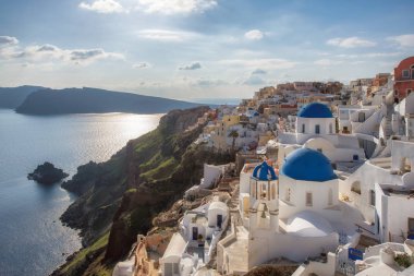 Yunan Santorini Adası'nda bahar zamanında Oia köyünün mavi kubbeli kiliseler üzerinde gün batımı.