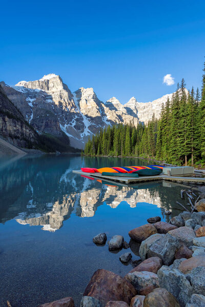 Moraine Lake with snow-covered peaks above it in Rocky Mountains, Canada.