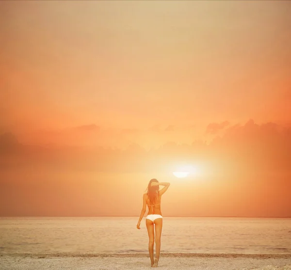Schöne sexuelle Frau gegen das Meer und den Sonnenuntergang — Stockfoto