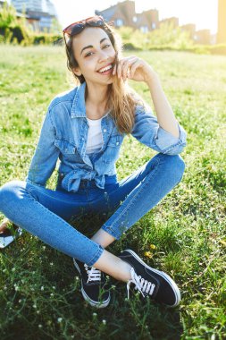 bir kadınla çimenlerin üzerinde bir parkta oturuyor