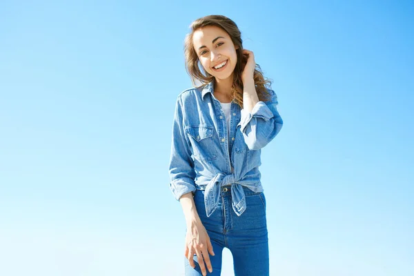 Ritratto di una giovane donna attraente sullo sfondo del cielo blu — Foto Stock
