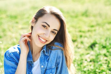 bir kadınla çimenlerin üzerinde bir parkta oturuyor