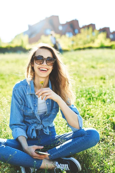 Una donna siede in un parco sull'erba — Foto Stock