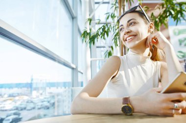 Alışveriş merkezindeki kafede oturan genç gülümseyen çekici kadın