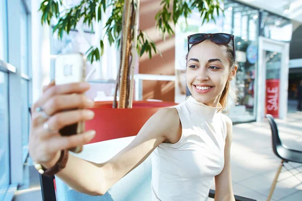 Joven mujer sonriente haciendo selfie en el centro comercial — Foto de Stock