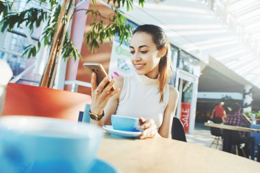 Alışveriş merkezindeki kafede oturan genç gülümseyen çekici kadın