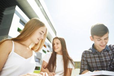Üç mutlu lise öğrencisinin portresi. Öğrenci arkadaşlar öğrenir, ödevlerini birlikte yapar, vakit geçirir ve eğlenirler..