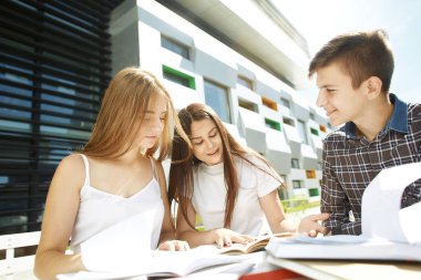 Üç mutlu lise öğrencisinin portresi. Öğrenci arkadaşlar öğrenir, ödevlerini birlikte yapar, vakit geçirir ve eğlenirler..