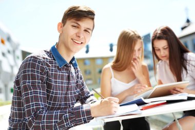 Üç lise öğrencisi. Öğrenci arkadaşlar öğrenir, ödevlerini birlikte yapar, dışarıda vakit geçirirler. Ön plandaki öğrenci.