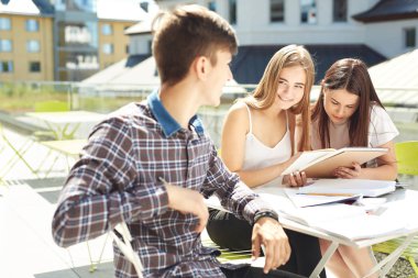 Üç lise öğrencisi. Öğrenci arkadaşlar öğrenir, ödevlerini birlikte yapar, dışarıda vakit geçirirler. Ön plandaki çocuk, kıza odaklan.