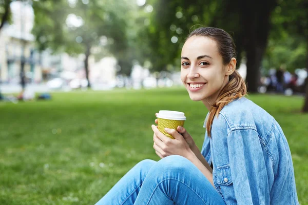 Atractiva Mujer Sonriente Sentada Con Taza Papel Caffee Hierba Parque — Foto de Stock